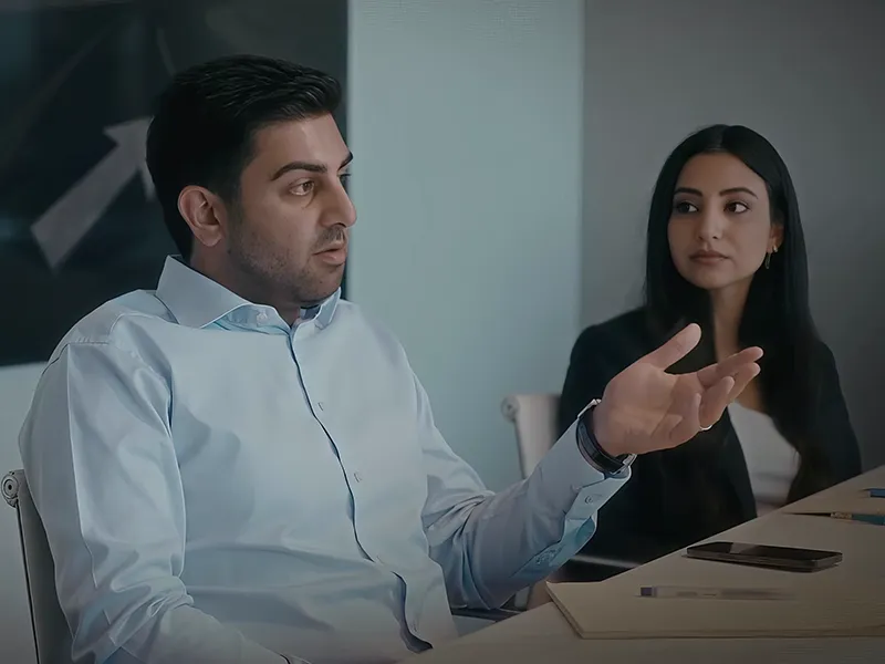 A law firm marketing director leading a strategy conversation with a colleague at a conference table