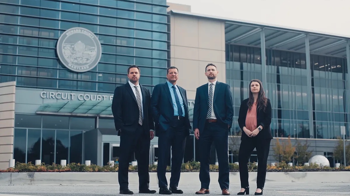 Plaxen Adler Muncy brand film thumbnail. Four people stand outside a glass building with the words Circuit Court and the Howard County Maryland seal visible on the facade.